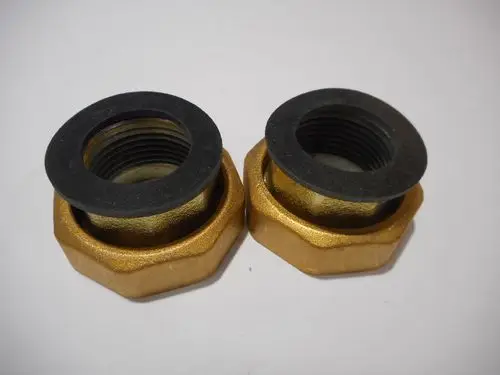 Zwei goldfarbene Anschlussteile mit schwarzem Gummi, passend für Rohrverbindungen. Remeha-Label auf der Oberfläche erkennbar.